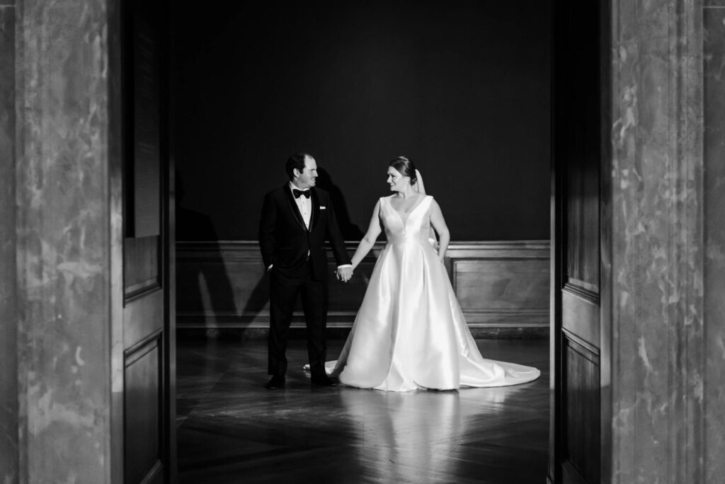 The bride and groom in between a beautiful doorway at a Baltimore Museum of Art Wedding planned by Blue Sapphire Events.
