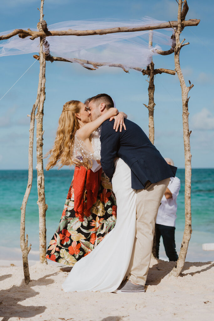 Bahamas Wedding Planner - Blue Sapphire Events for a destination wedding the couple Emily and Adam kiss at their wedding ceremony.